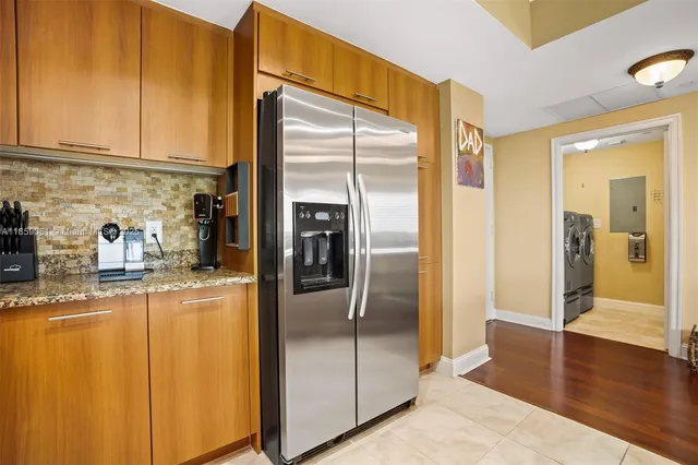 a kitchen with stainless steel appliances granite countertop a refrigerator and a stove