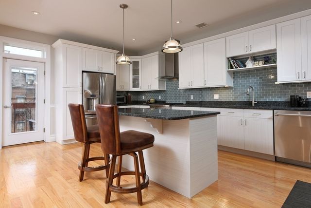 a kitchen with stainless steel appliances granite countertop a stove a sink a refrigerator and a microwave