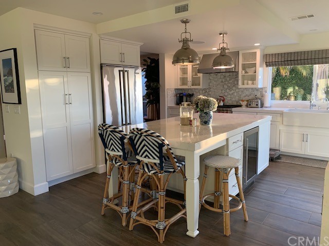 5 Regatta Way Dana Point, CA 92629 - Photo 13 of 36 a kitchen with stainless steel appliances kitchen island granite countertop a refrigerator a stove a sink dishwasher with a dining table and chairs