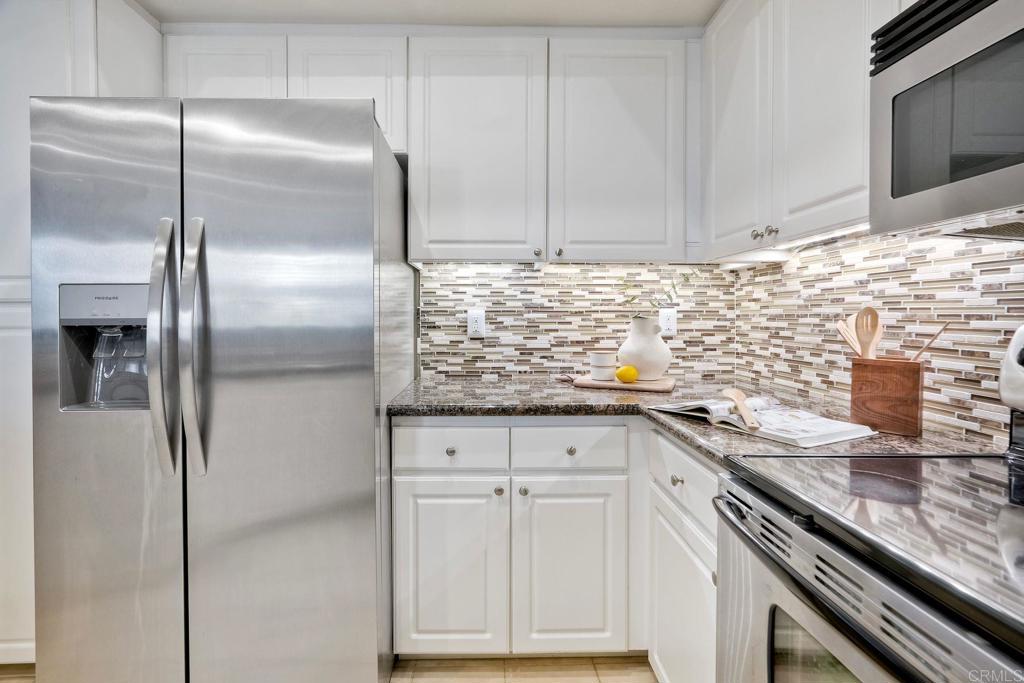 9263 Regents Road, Unit B106 La Jolla, CA 92037 - Photo 11 of 35 a kitchen with granite countertop a sink stainless steel appliances and cabinets