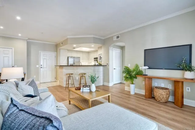 a living room with furniture a flat screen tv and a large window
