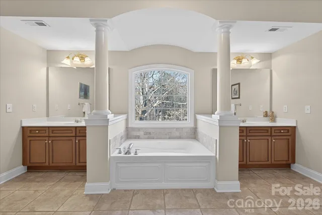 a bathroom with a tub a sink and a large mirror