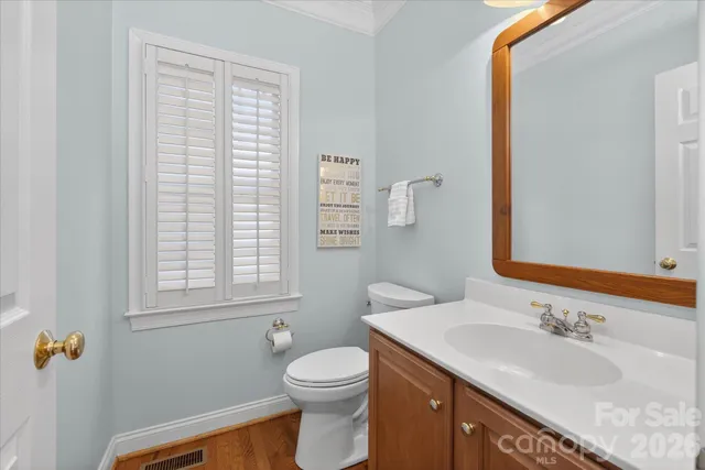 a bathroom with a granite countertop sink toilet and mirror