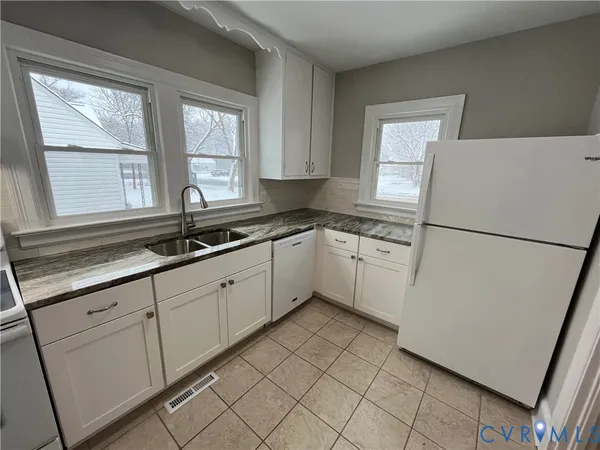 a kitchen with white cabinets and white appliances