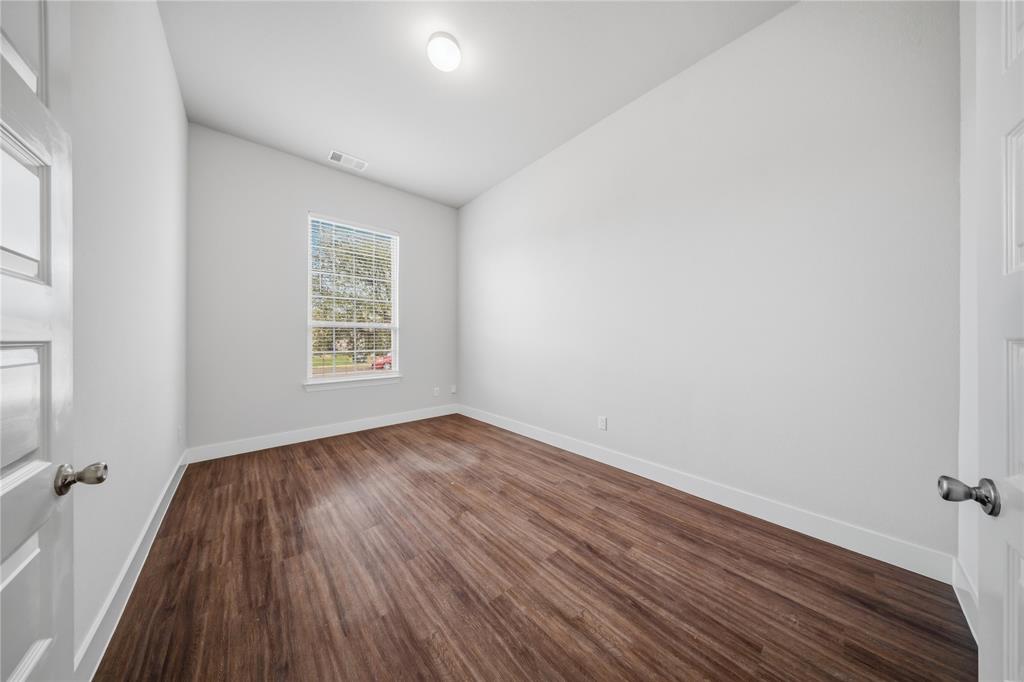 1665 Sheldon Drive Forney, TX 75126 - Photo 21 of 35 an empty room with wooden floor and windows