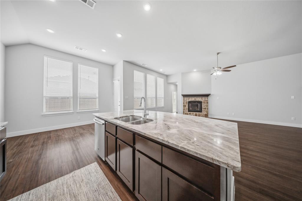 1665 Sheldon Drive Forney, TX 75126 - Photo 3 of 35 an empty room with wooden floor and a kitchen