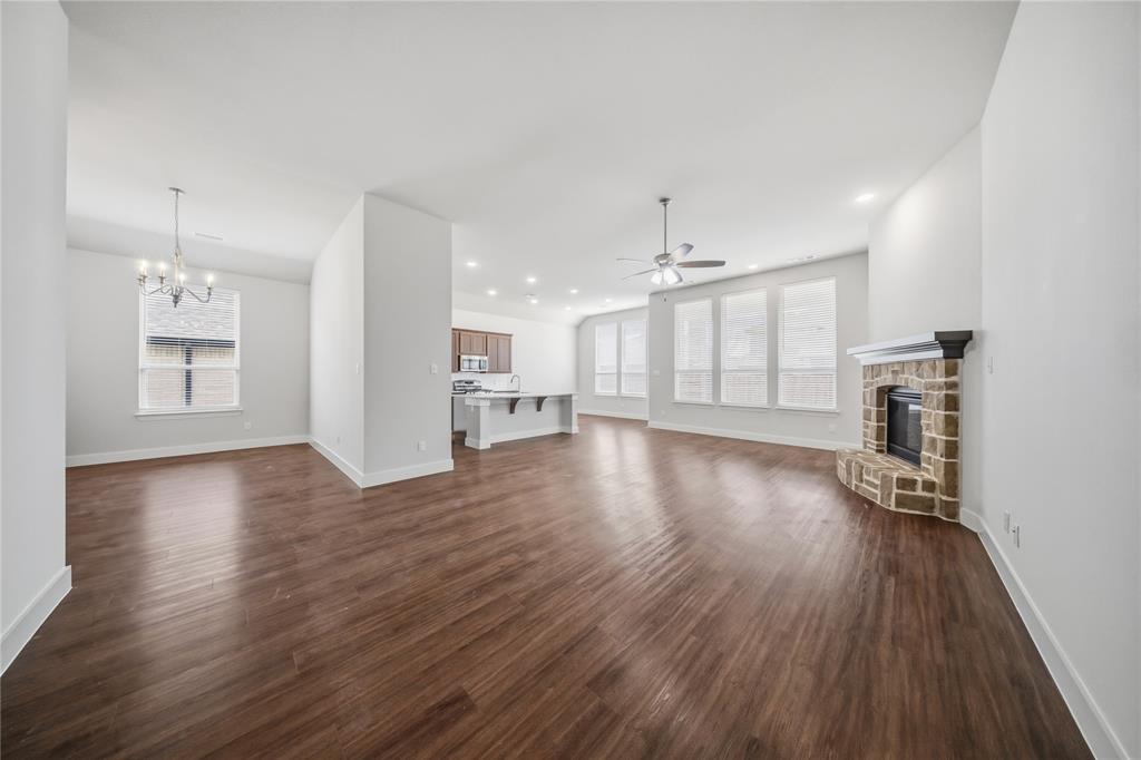 1665 Sheldon Drive Forney, TX 75126 - Photo 6 of 35 an empty room with wooden floor and kitchen view