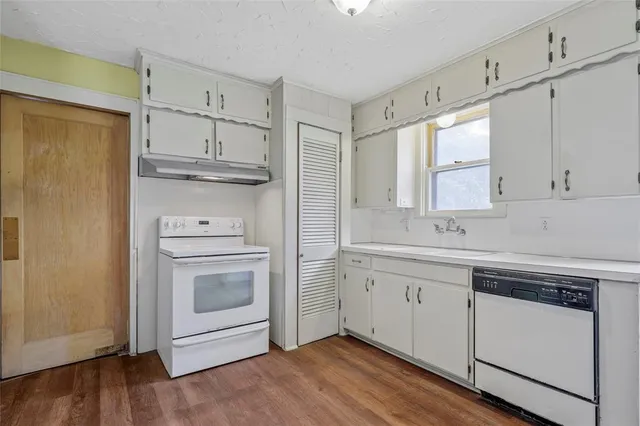 a kitchen with white cabinets stainless steel appliances and sink