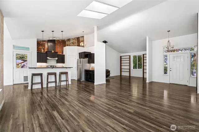a living room with furniture wooden floor and a kitchen view