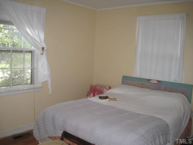 2135 Milburnie Road Raleigh, NC 27610 - Photo 12 of 17 a bedroom with a bed a window and a mirror