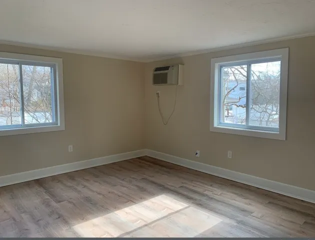 a view of an empty room with wooden floor