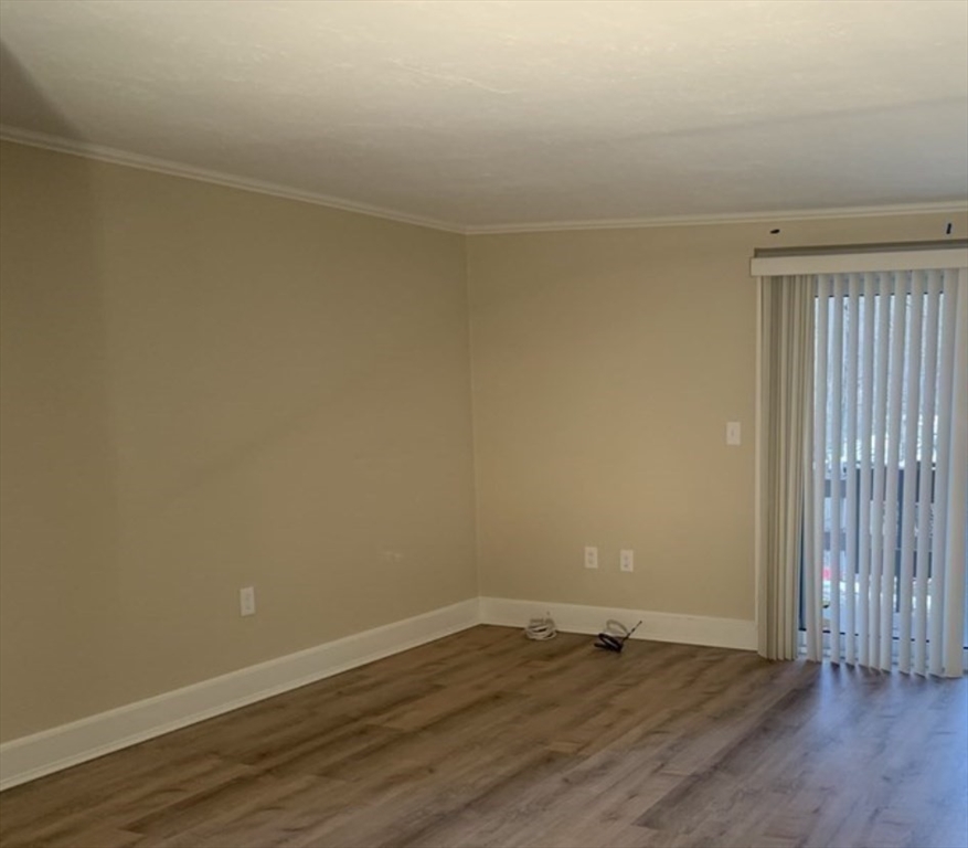 10 Mill Street, Unit X Maynard, MA 01754 - Photo 15 of 17 a view of an empty room with wooden floor and a window