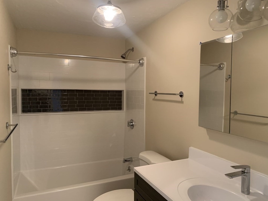 10 Mill Street, Unit X Maynard, MA 01754 - Photo 16 of 17 a bathroom with a shower a sink and a toilet