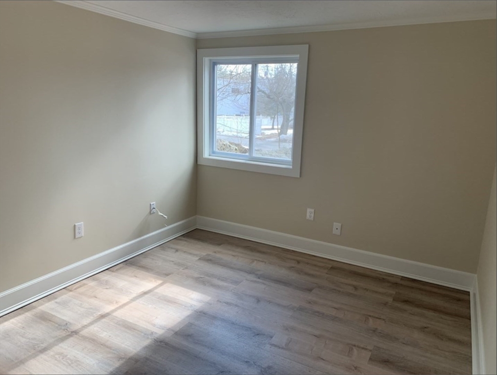 10 Mill Street, Unit X Maynard, MA 01754 - Photo 5 of 17 an empty room with wooden floor and windows