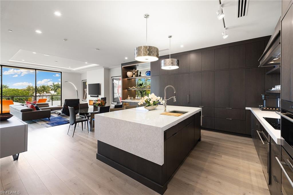 495 5th Street South, Unit 304 Naples, FL 34102 - Photo 12 of 33 a kitchen with a sink stove and cabinets