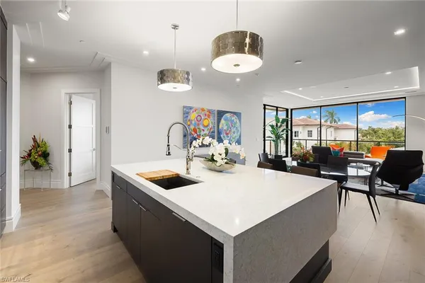 a kitchen with a stove a kitchen island a dining table and chairs with wooden floor