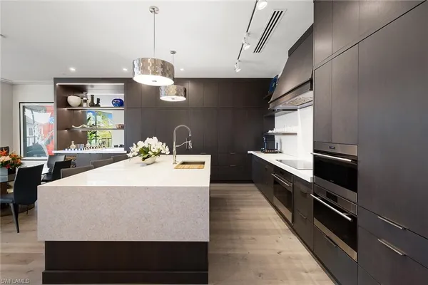 a kitchen with kitchen island a counter top space appliances and a ceiling fan