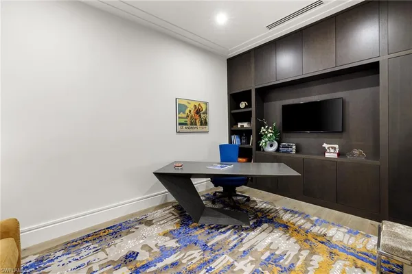 a bedroom with a large bed and a flat tv screen