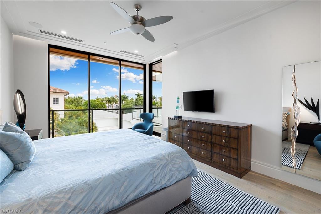 495 5th Street South, Unit 304 Naples, FL 34102 - Photo 22 of 33 a bedroom with a large bed and a flat screen tv