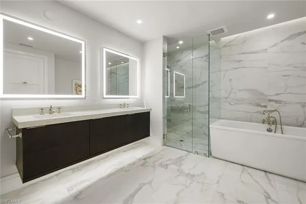 a bathroom with a bathtub sink shower and mirror