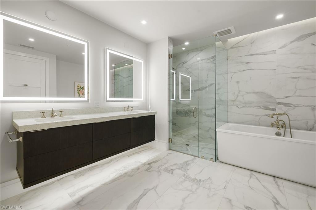 495 5th Street South, Unit 304 Naples, FL 34102 - Photo 23 of 33 a bathroom with a bathtub sink shower and mirror