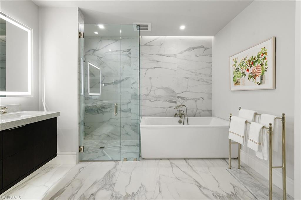 495 5th Street South, Unit 304 Naples, FL 34102 - Photo 24 of 33 a bathroom with a bathtub sink shower and mirror