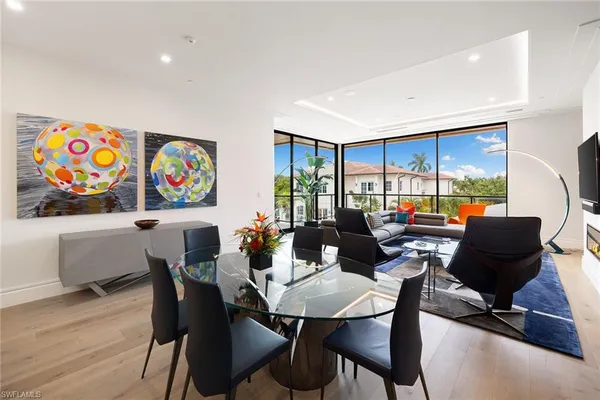 a living room with furniture a rug and a floor to ceiling window