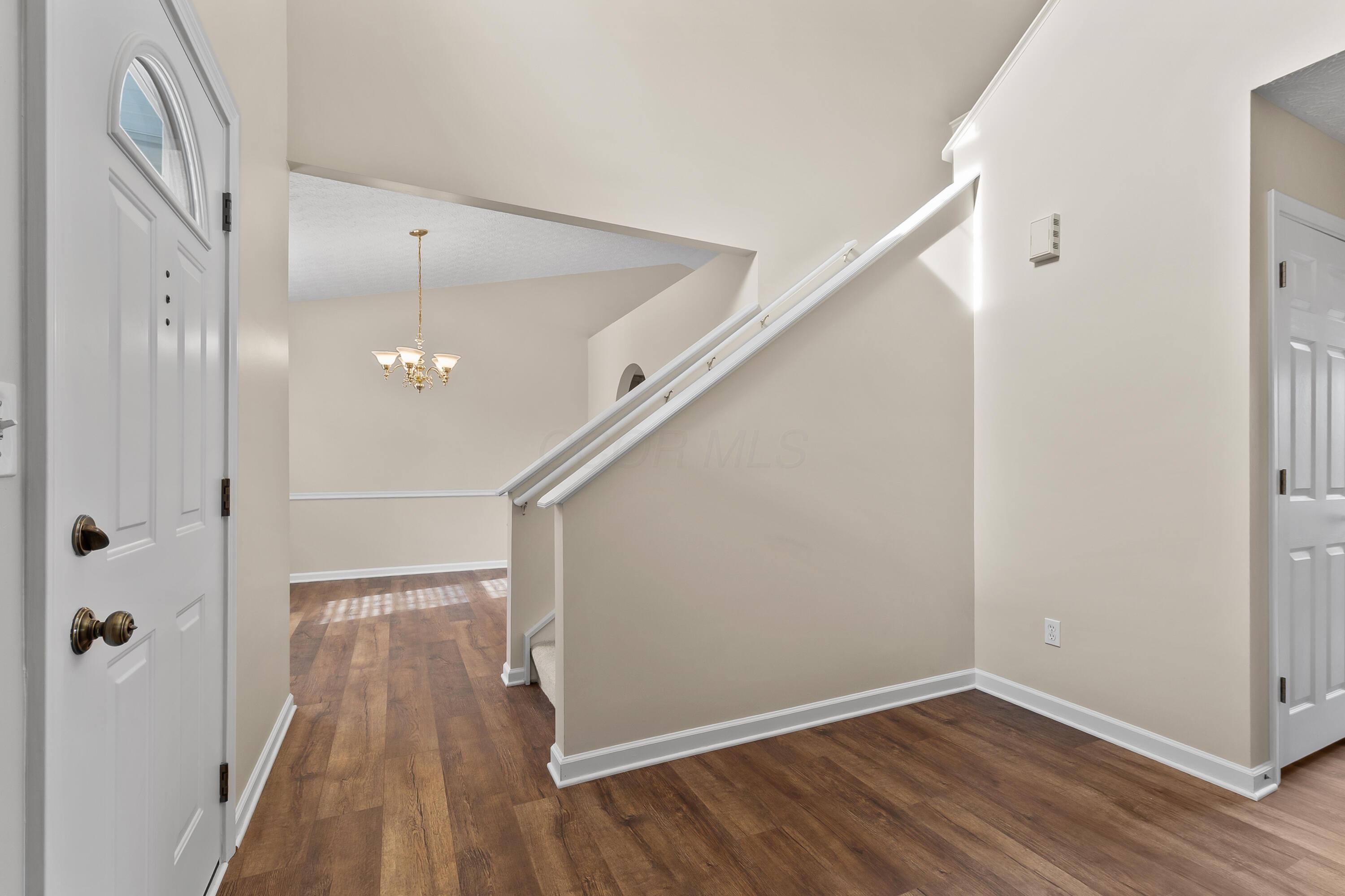 30 Tabilore Loop Delaware, OH 43015 - Photo 5 of 55 • New luxury vinyl plank flooring ~ 2025 • Tan painted walls • Two-story ceiling • Chandelier • Coat closet with bi-fold doors