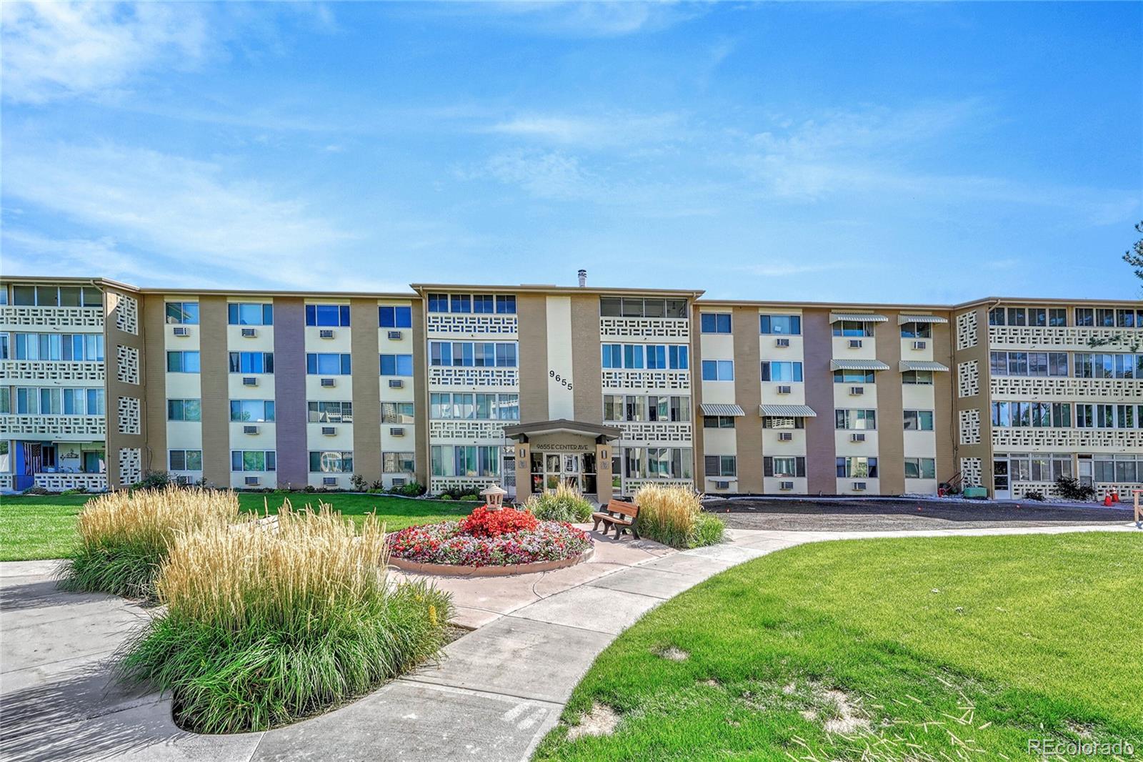 9655 Center Avenue, Unit 9D Denver, CO 80247 - Photo 13 of 21 a front view of a building with a garden and plants