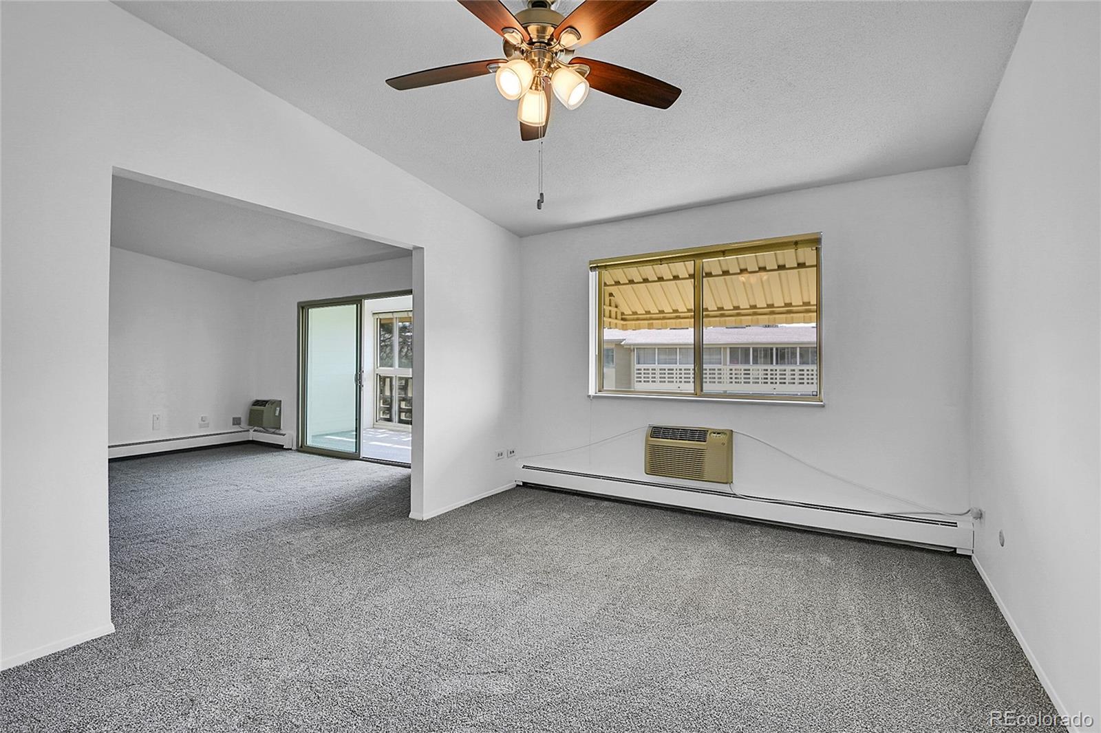 9655 Center Avenue, Unit 9D Denver, CO 80247 - Photo 18 of 21 a view of an empty room with window and chandelier fan