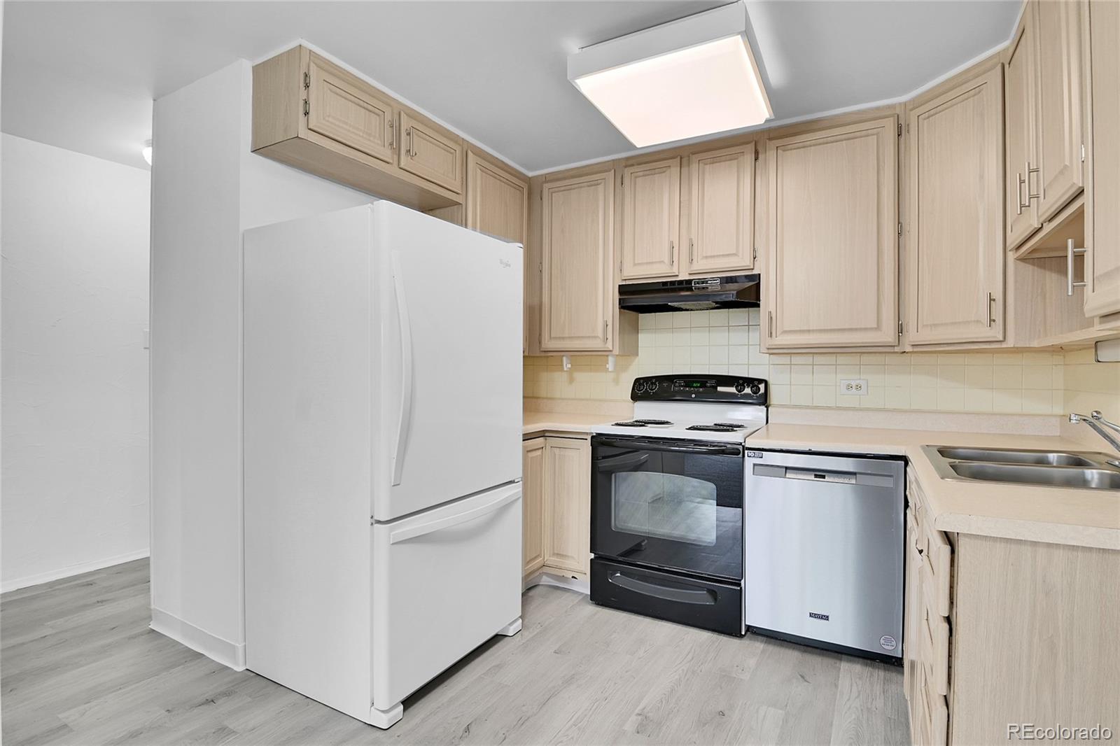 9655 Center Avenue, Unit 9D Denver, CO 80247 - Photo 4 of 21 a kitchen with a white stove and refrigerator