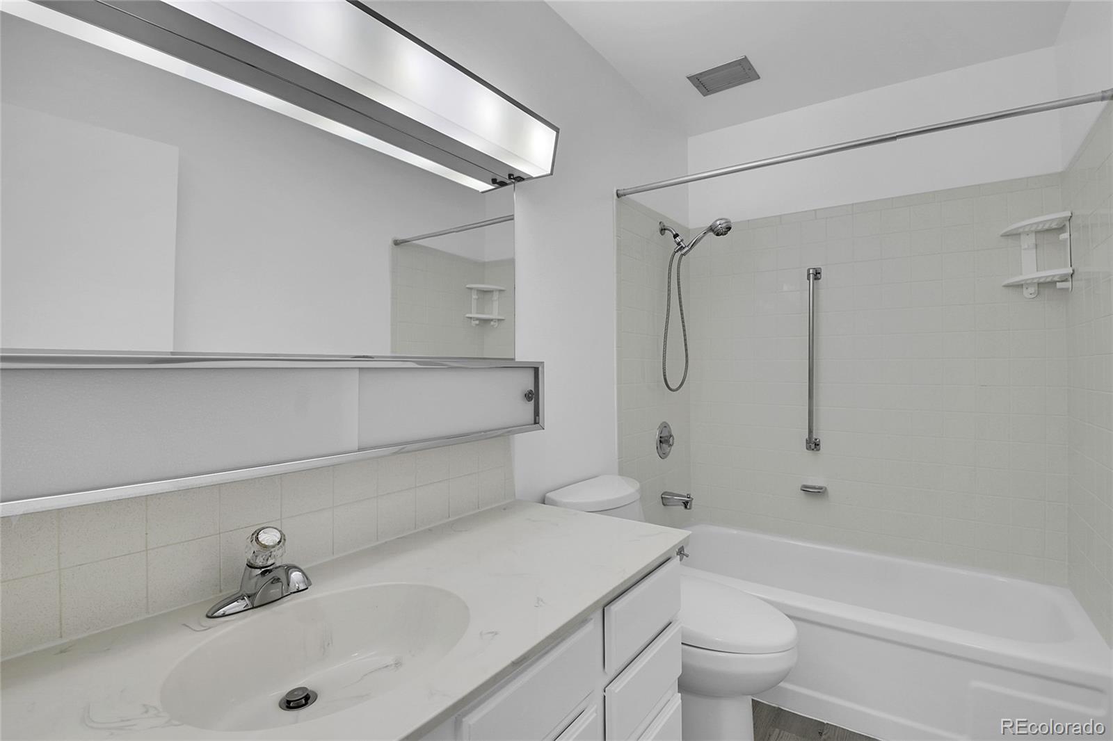 9655 Center Avenue, Unit 9D Denver, CO 80247 - Photo 8 of 21 a bathroom with a sink a toilet and shower