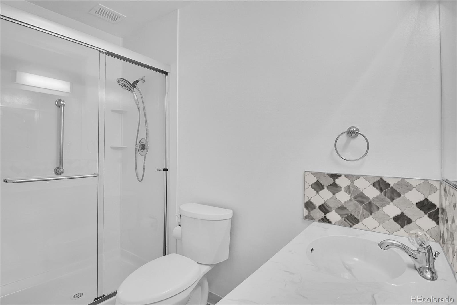 9655 Center Avenue, Unit 9D Denver, CO 80247 - Photo 9 of 21 a white toilet sitting next to a bathroom sink
