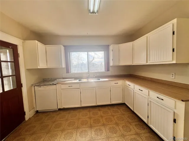 a kitchen with granite countertop white cabinets white stainless steel appliances with a sink and dishwasher