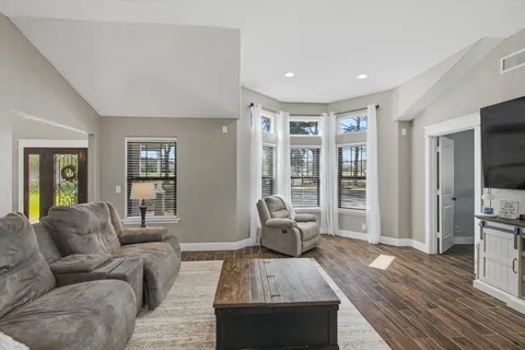 a living room with furniture and wooden floor