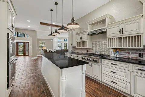 a kitchen with granite countertop a sink and a stove