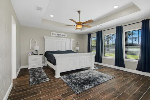 a bedroom with a large bed a chandelier and view of the kitchen