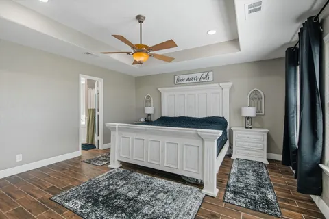 a bedroom with a bed and a table with wooden floor