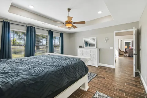 a bedroom with a large bed chandelier and a window