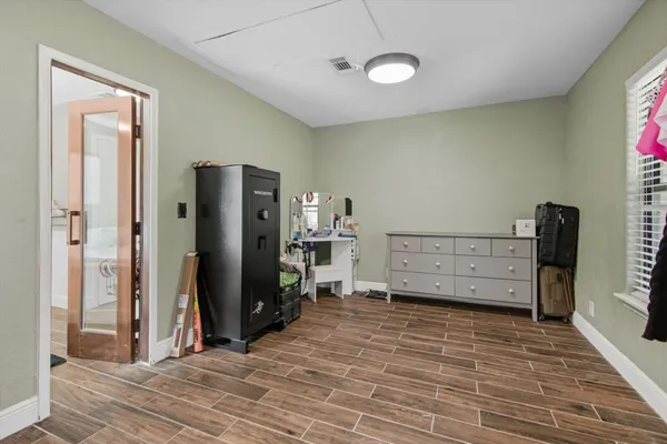 a view of a bedroom with wooden floor