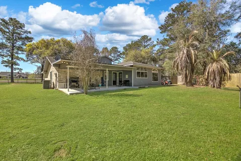 a front view of a house with a garden and trees
