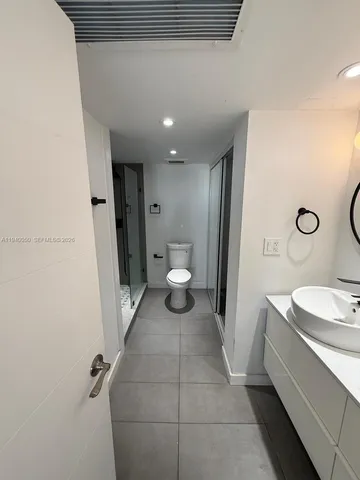 a bathroom with a sink a toilet and a mirror