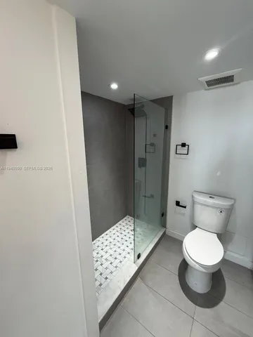 a bathroom with a toilet and a shower