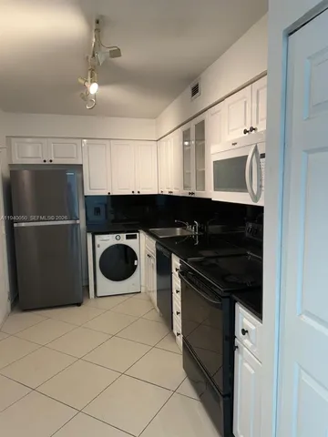 a kitchen with stainless steel appliances granite countertop a refrigerator and a stove
