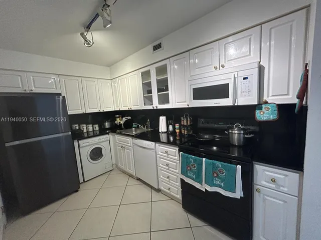 a kitchen with granite countertop a refrigerator and a sink