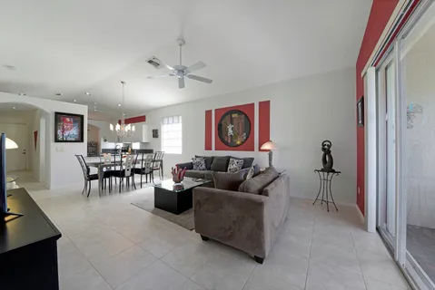 a living room with furniture a chandelier and a window