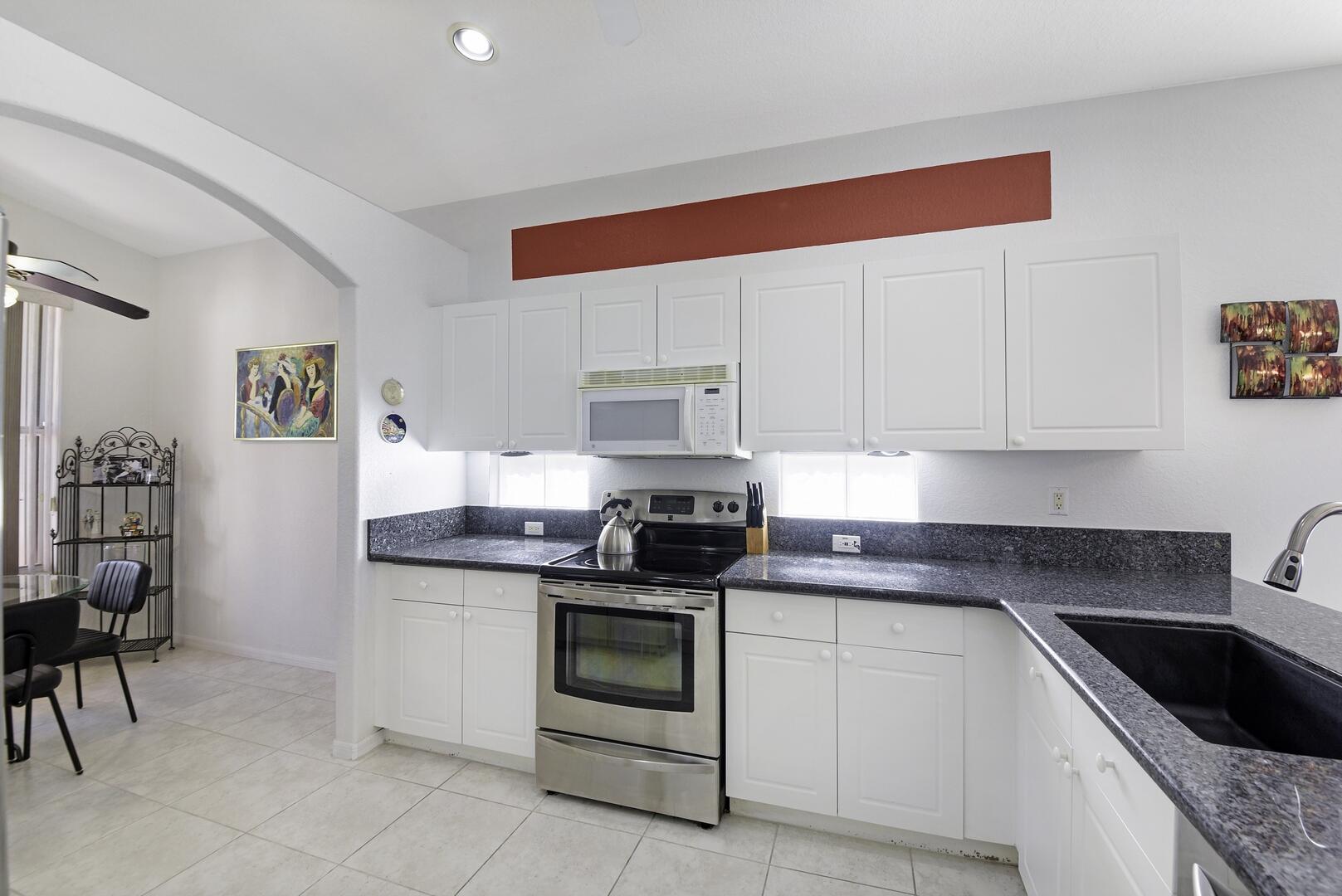 8214 Bellafiore Way Boynton Beach, FL 33472 - Photo 6 of 35 a kitchen with granite countertop white cabinets and appliances