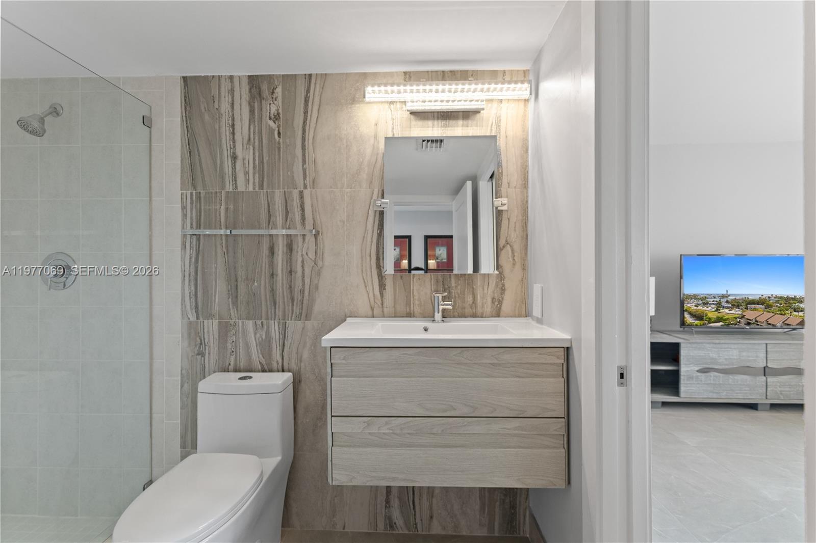 2611 North Riverside Drive, Unit 901 Pompano Beach, FL 33062 - Photo 16 of 27 a bathroom with a toilet sink and mirror