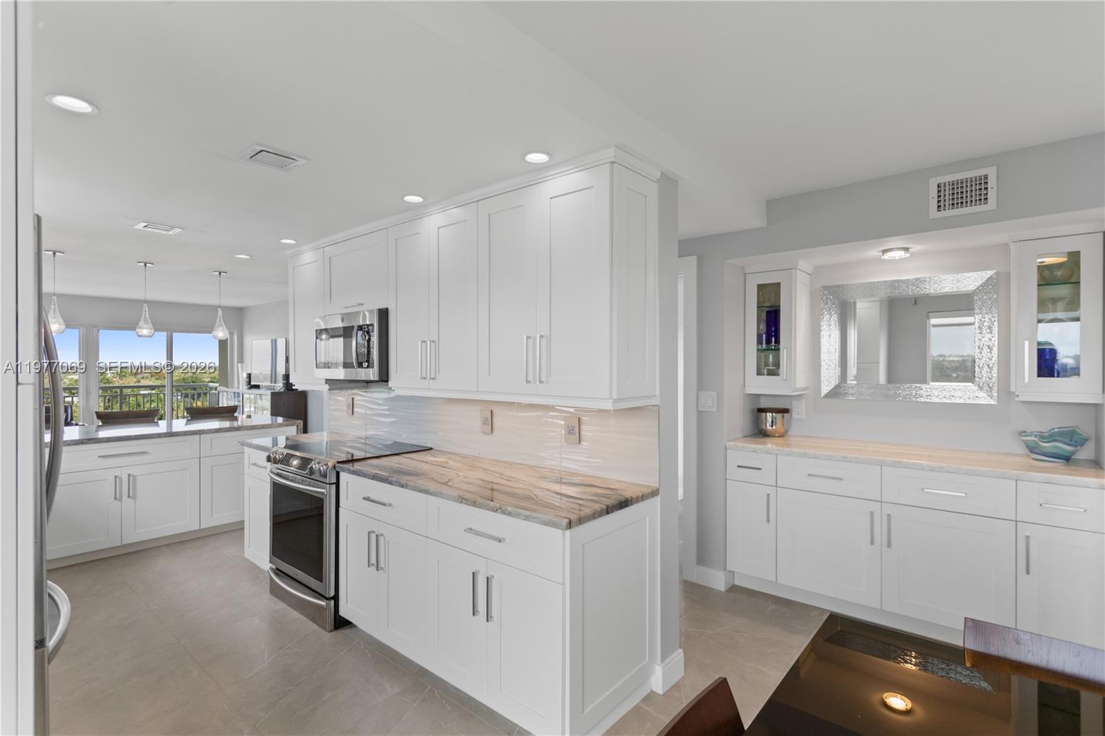 2611 North Riverside Drive, Unit 901 Pompano Beach, FL 33062 - Photo 4 of 27 a kitchen that has a sink and a stove in it