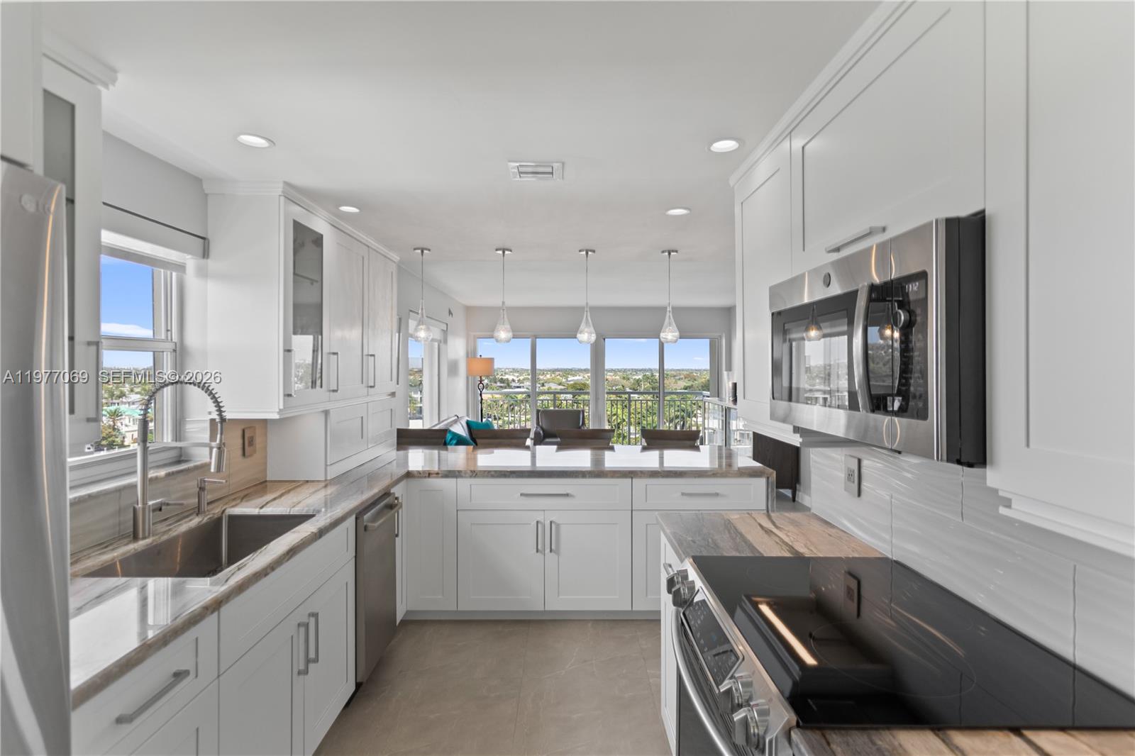 2611 North Riverside Drive, Unit 901 Pompano Beach, FL 33062 - Photo 5 of 27 a large kitchen with a large window and stainless steel appliances